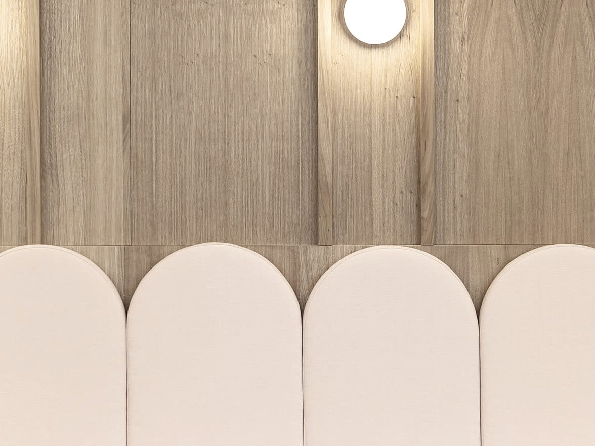 Banquette sur mesure à dossiers arrondis devant un mur en panneaux de bois