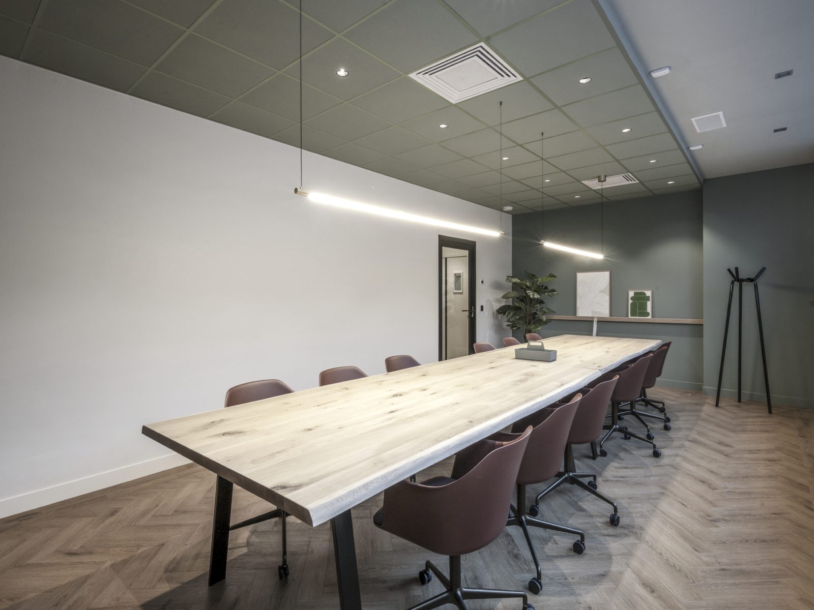 Salle de réunion avec grande table en bois massif et fauteuils de bureau