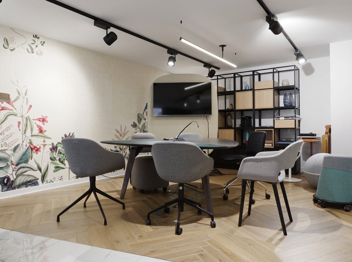 Salle de réunion du showroom : table ronde, fauteuils gris et papier peint floral